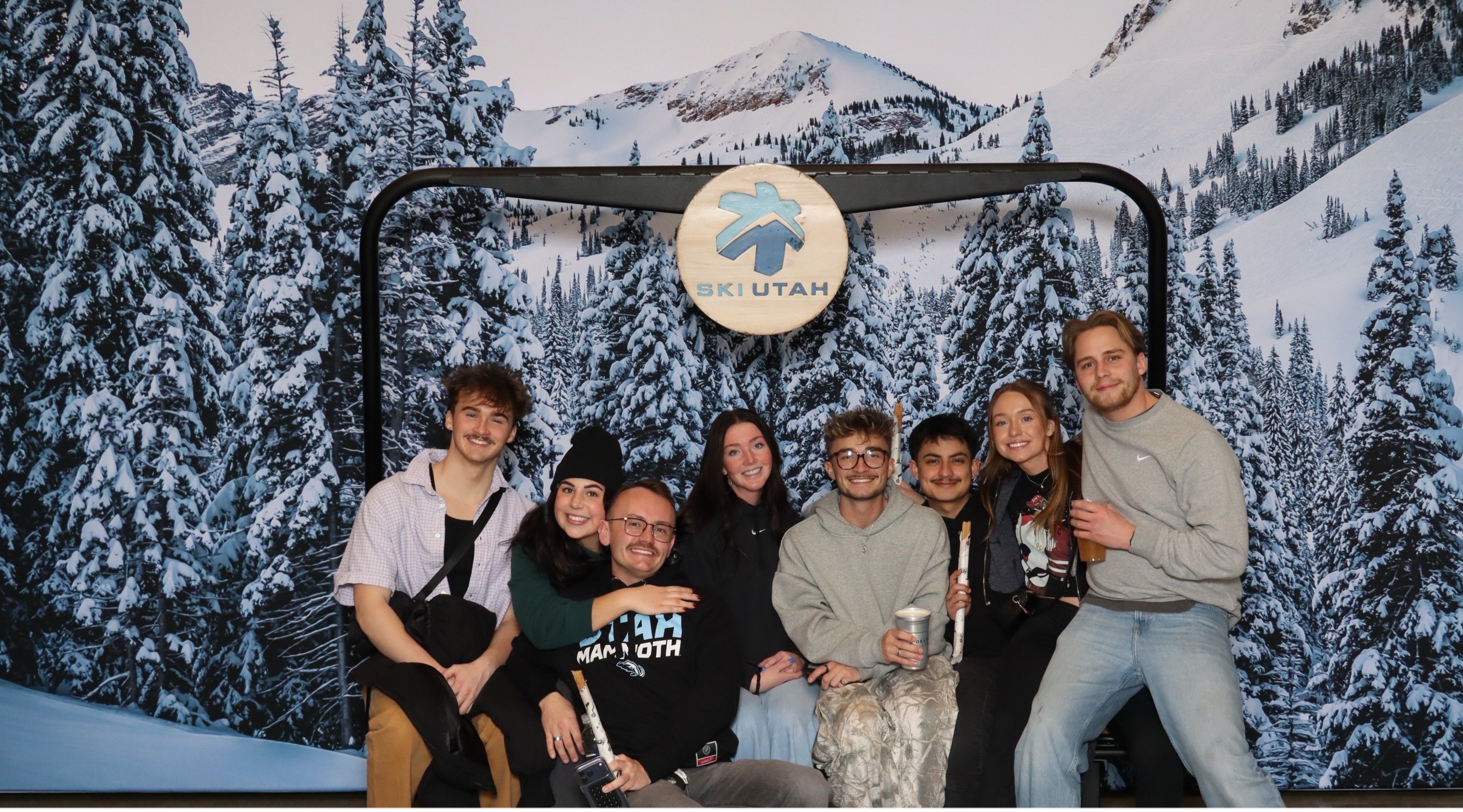 Guests at a branded corporate activation in front of a custom backdrop