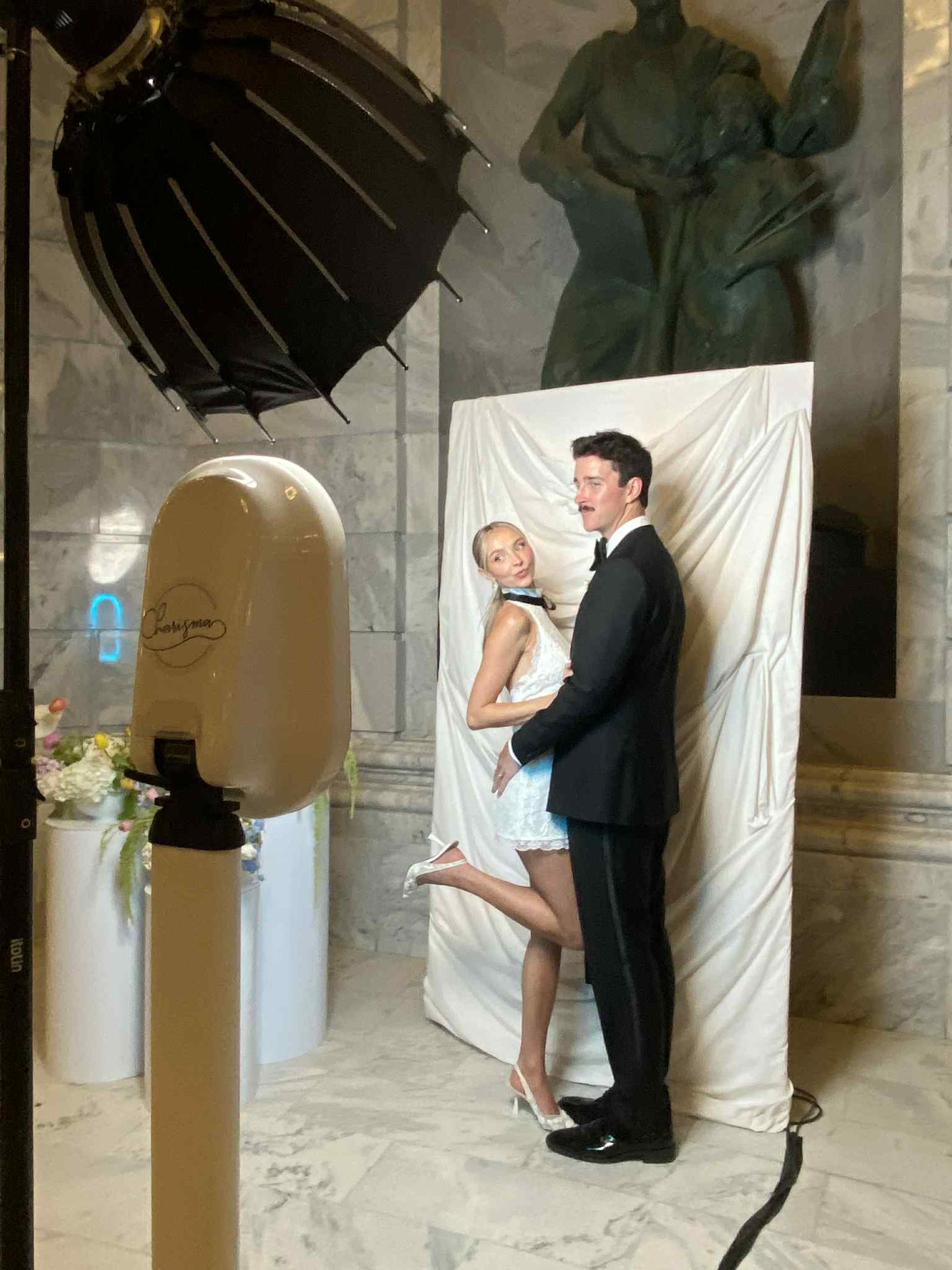 A couple posing at the photo booth in a stone venue