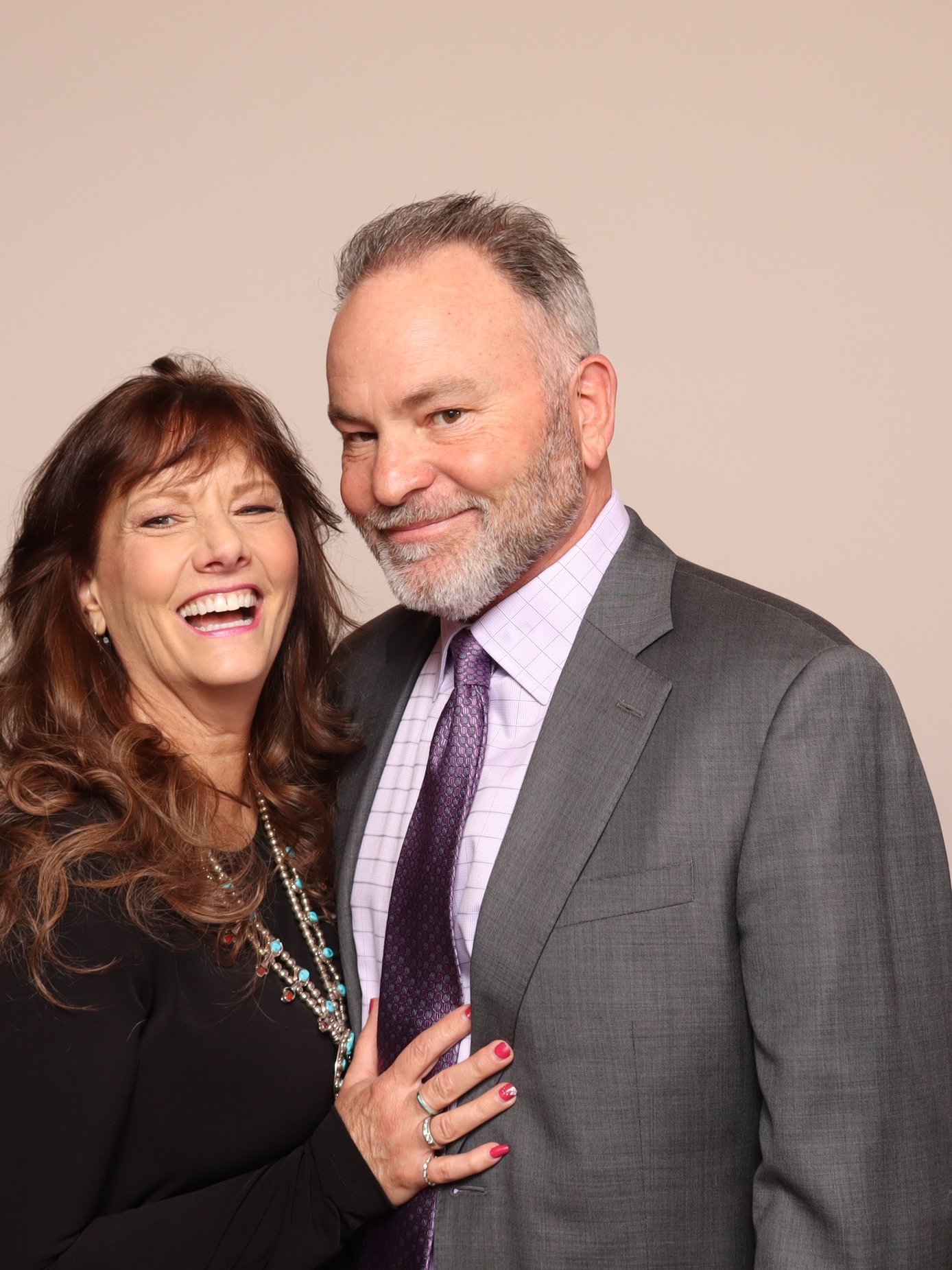 A couple laughing together under studio lighting