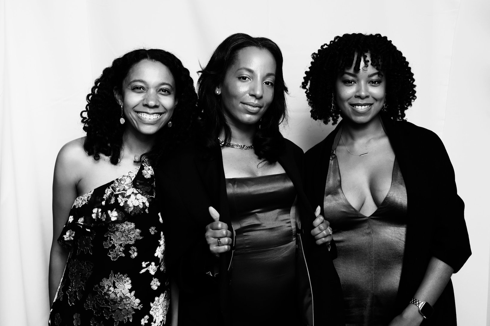 Friends posing together in black and white on a white backdrop